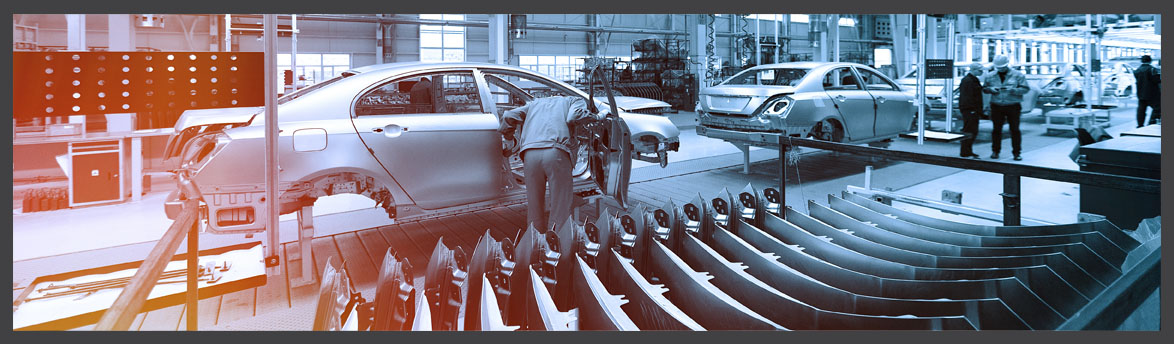 Workers assembling car bodies on a modern automotive production line, with vehicle frames and metal components visible in the factory.